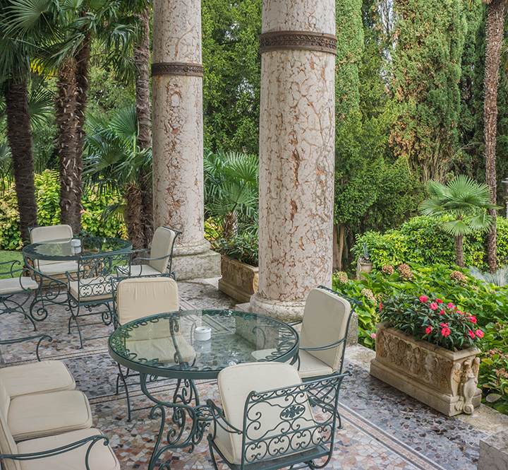 Patio at the Villa Cortine Palace Hotel in Sirmione, Italy. The building materials and details, furniture, and view each contribute to the biophilic experience of the space. Patio at the Villa Cortine Palace Hotel in Sirmione, Italy. The building materials and details, furniture, and view each contribute to the biophilic experience of the space.